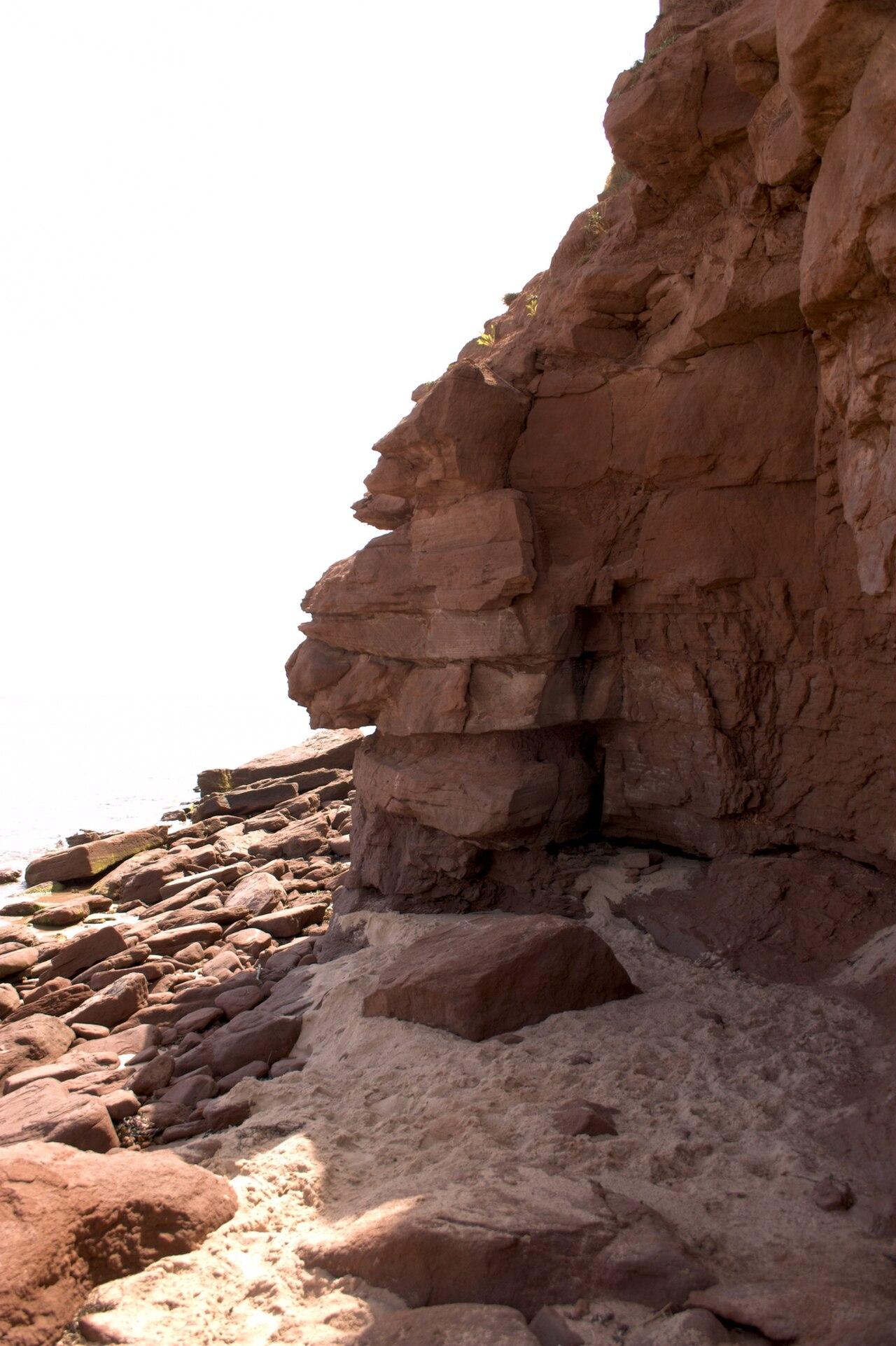 Layered red sandstone and a pocket of sand at Basin Head Provincial Park